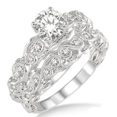 a white gold ring set with an intricate design and round brilliant cut diamond in the center