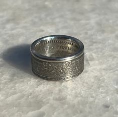 a silver ring with the word king written on it sitting on a white table top