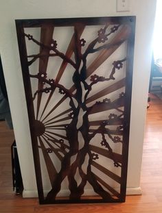 a decorative metal screen on the wall in a room with hardwood floors and hard wood flooring