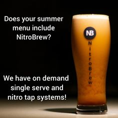 a glass filled with liquid sitting on top of a table next to a sign that says, does your summer menu include nitrobrew?