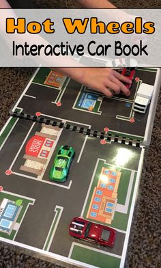 a child playing with a toy car game on the floor and text overlay that reads, hot wheels interactive car book