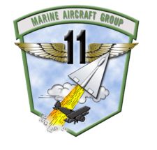 the logo for marine aircraft group 11, with a rocket launching from it's tail