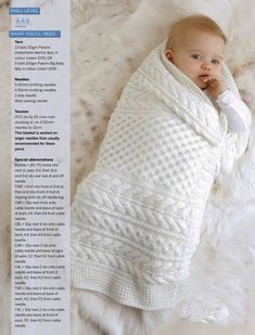 a baby wrapped in a white blanket laying on top of a furnishing area