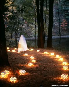 a black and white photo with glowing pumpkins in the grass next to a tree