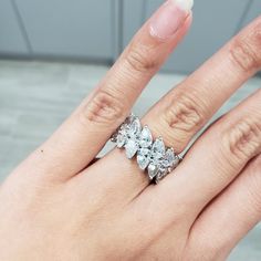 a woman's hand with an engagement ring on her finger and three stones in the middle