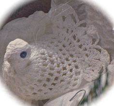 a white crocheted stuffed animal in a basket