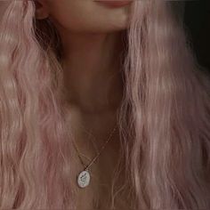 a woman with long pink hair wearing a necklace