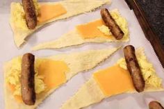 sausages and eggs are on top of tortilla shells with cheese in them