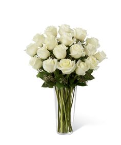 a vase filled with white roses on top of a table