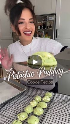 a woman is making cookies with green icing