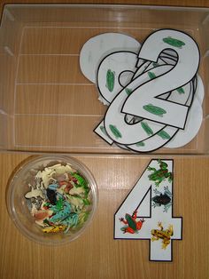 the number four is next to a plastic container with various stickers and magnets on it