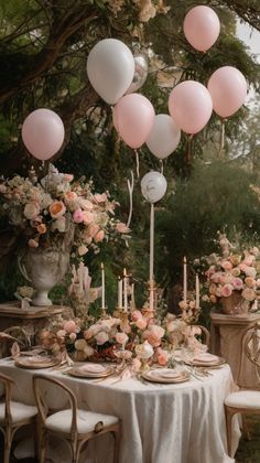 the table is set with pink and white balloons