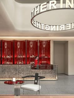 the interior of a modern bar with red cabinets and white chairs in front of it