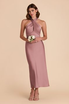 a bridesmaid in a long, halter - neck dress with flowers on the waist