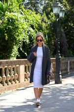 a woman is walking down the street with her hand on her hip while wearing sunglasses