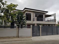 a two story house with a fenced in yard and trees on the other side