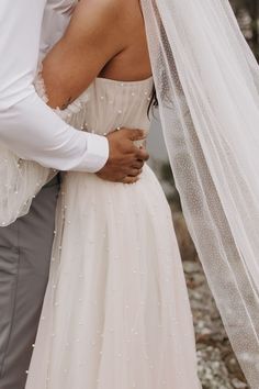 a bride and groom standing close to each other under a veil on their wedding day