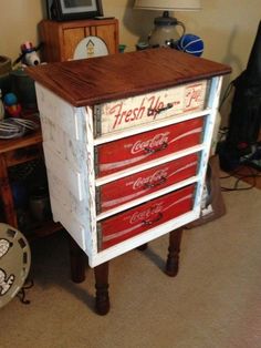 an old chest of drawers with coca cola painted on it