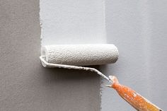 a roll of paint is being painted on the wall with a roller attached to it