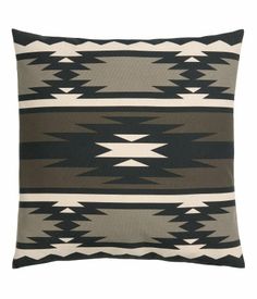 a black and white pillow with an abstract design on the front, in grey tones