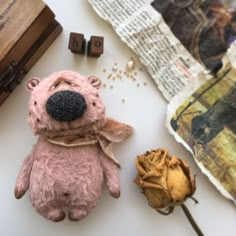 a stuffed animal sitting on top of a table next to some flowers and other items