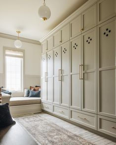 a large room with white cabinets and lots of pillows