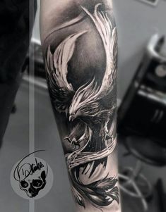 a man's arm with a black and white tattoo design on it, featuring an eagle