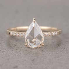 an engagement ring with a pear shaped diamond in the center