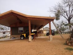 a truck parked in front of a house under a wooden roof