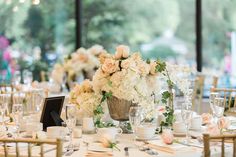 the table is set with white and pink flowers