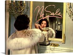 a woman is looking at herself in the mirror and writing on her face with pink ink