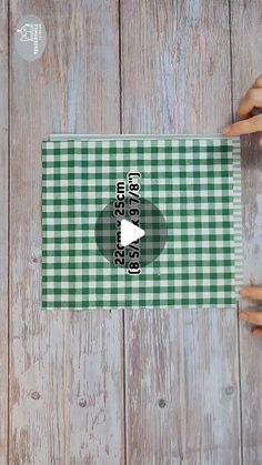 two hands holding onto a green and white checkered table cloth