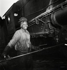 an old black and white photo of a man standing next to a train