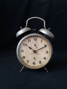 an old fashioned alarm clock on a black background