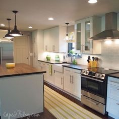 a kitchen with white cabinets and stainless steel appliances