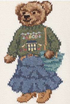 a teddy bear is wearing a sweater and holding a house on it's chest