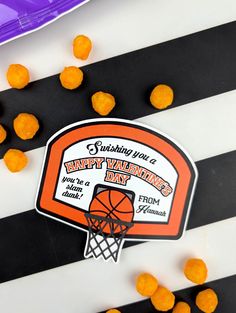 an orange and white striped table cloth with basketball themed stickers on it that says happy valentine's day