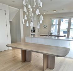 a large wooden table sitting in the middle of a kitchen