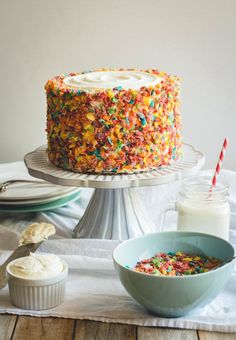 a cake with sprinkles on it sitting on a table next to other food