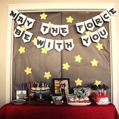 a red table topped with lots of food and desserts next to a sign that says may the force be with you