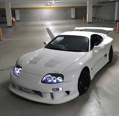 a white sports car parked in a parking garage