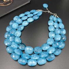 Brighten up your day with our Caribbean Blue Chunky Necklace. This vibrant multi strand statement necklace features deep Caribbean blue beads, handcrafted for a bold and beautiful look. Perfect as a gift for her, this eye-catching piece adds a splash of tropical color to any outfit, making it a standout accessory for any occasion. - Necklace length is 16" shortest strand plus additional 3 inch extender chain for length adjustment. Matching earrings are available. Select from the option drop-down Jewelry Chunky, Autumn Necklace, Necklace Big, Chunky Statement Necklace, Christmas Necklace, Caribbean Blue, Multi Layer Necklace, Tropical Getaways, Key Necklace