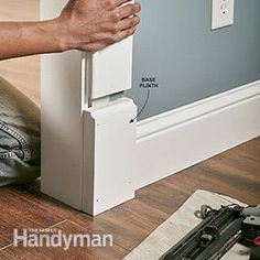 a person is sitting on the floor with their hand near an electrical outlet and screwdriver