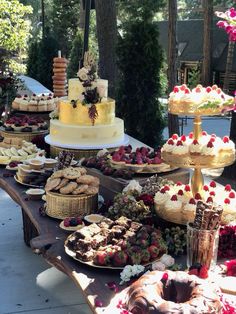 a table filled with lots of different types of cakes and desserts