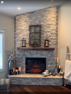 a living room with a fire place in the corner and candles on top of it