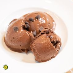 two chocolate ice creams on a white plate with some chocolate chips in the middle