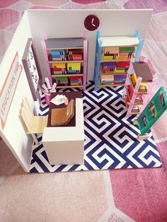 a doll house with furniture and books on the floor