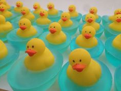 many yellow rubber ducks sitting on top of blue plastic cups