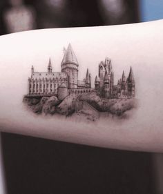 a tattoo on the arm of a person with a castle