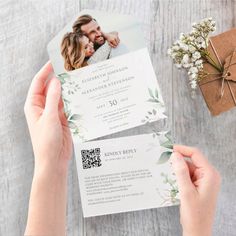 two people holding up some wedding cards